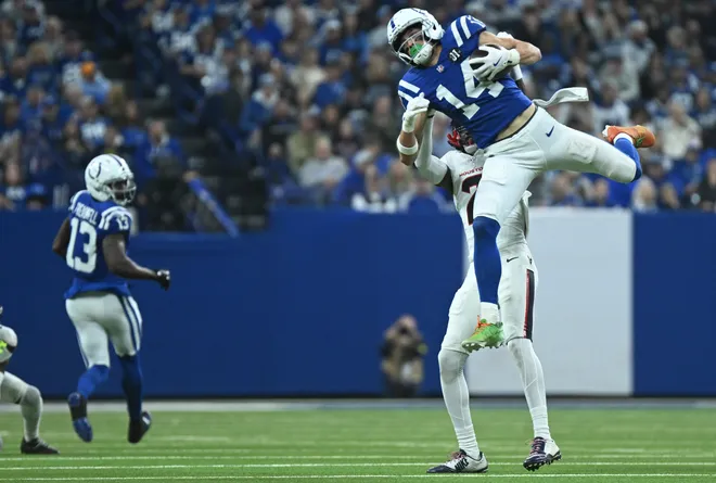 Nov 30, 2025; Indianapolis, Indiana, USA; Indianapolis Colts wide receiver Alec Pierce (14) makes a catch against Houston Texans safety Calen Bullock (2) during the first half at Lucas Oil Stadium. Mandatory Credit: Robert Goddin-Imagn Images