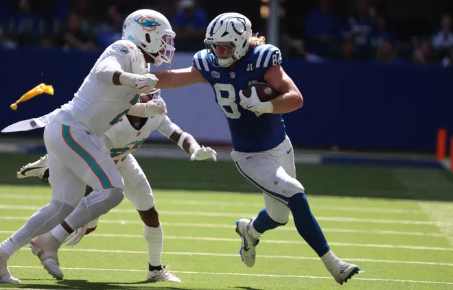 Sep 7, 2025; Indianapolis, Indiana, USA; Indianapolis Colts tight end Tyler Warren (84) runs against Miami Dolphins linebacker Bradley Chubb (2) and cornerback Jack Jones (23) during the second half at Lucas Oil Stadium. Mandatory Credit: Trevor Ruszkowski-Imagn Images