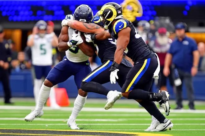 Seattle Seahawks running back Kenneth Walker III is tackled by Los Angeles Rams linebacker Nate Landman.