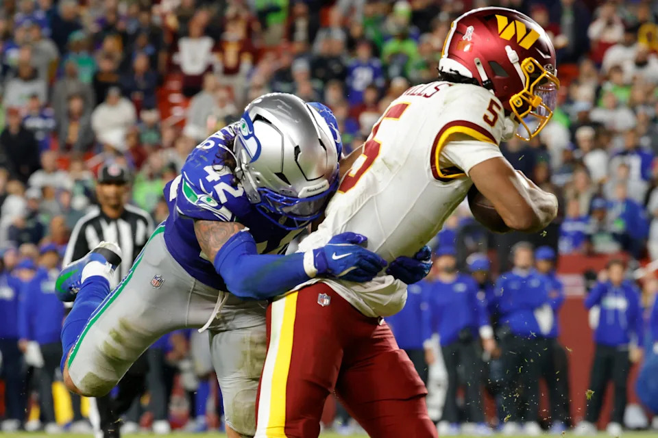 Seattle Seahawks linebacker Drake Thomas tackles Washington Commanders quarterback Jayden Daniels.