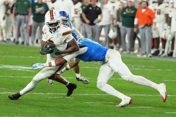 Miami wide receiver Keelan Marion (0) runs with the ball against Mississippi cornerback Jaylon Braxton (2) during the second half of the Fiesta Bowl NCAA college football playoff semifinal game, Thursday, Jan. 8, 2026, in Glendale, Ariz. (AP Photo/Ross D. Franklin)