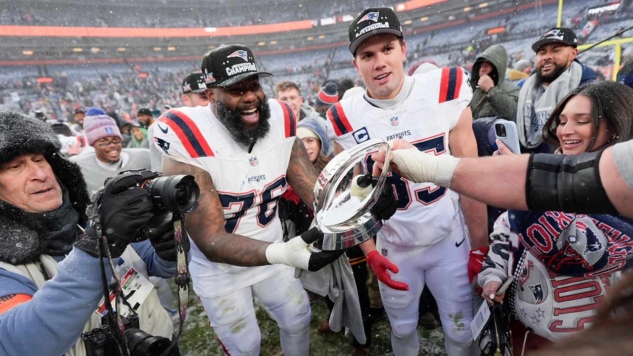 New England Patriots offensive tackle Morgan Moses (76) and tight end Hunter Henry celebrate after the AFC Championship NFL football game against the Denver Broncos, Sunday, Jan. 25, 2026, in Denver. (AP Photo/Ashley Landis)