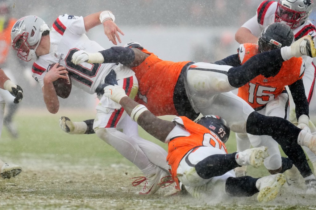 New England Patriots quarterback Drake Maye is tackled by Denver Broncos defensive tackle Malcolm Roach during the second the half of the AFC Championship NFL football game, Monday, Jan. 26, 2026, in Denver.