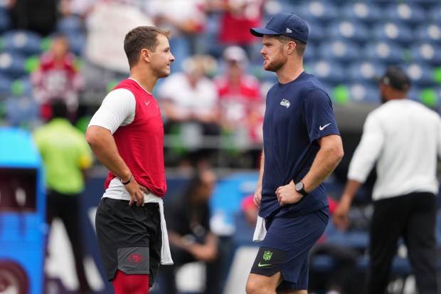 San Francisco 49ers quarterback Brock Purdy, left, and Seattle Seahawks quarterback Sam Darnold, right, talk before an NFL football game Sunday, Sept. 7, 2025, in Seattle. (AP Photo/Lindsey Wasson)