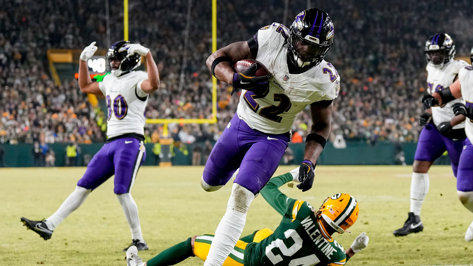 Baltimore Ravens running back Derrick Henry (22) runs for a touchdown past Green Bay Packers cornerback Carrington Valentine (24) during the second quarter at Lambeau Field.