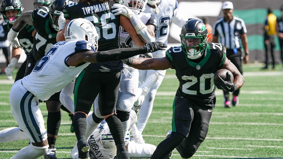 New York Jets running back Breece Hall (20) carries the ball as he works around Dallas Cowboys safety Donovan Wilson (6) during the first half at MetLife Stadium.