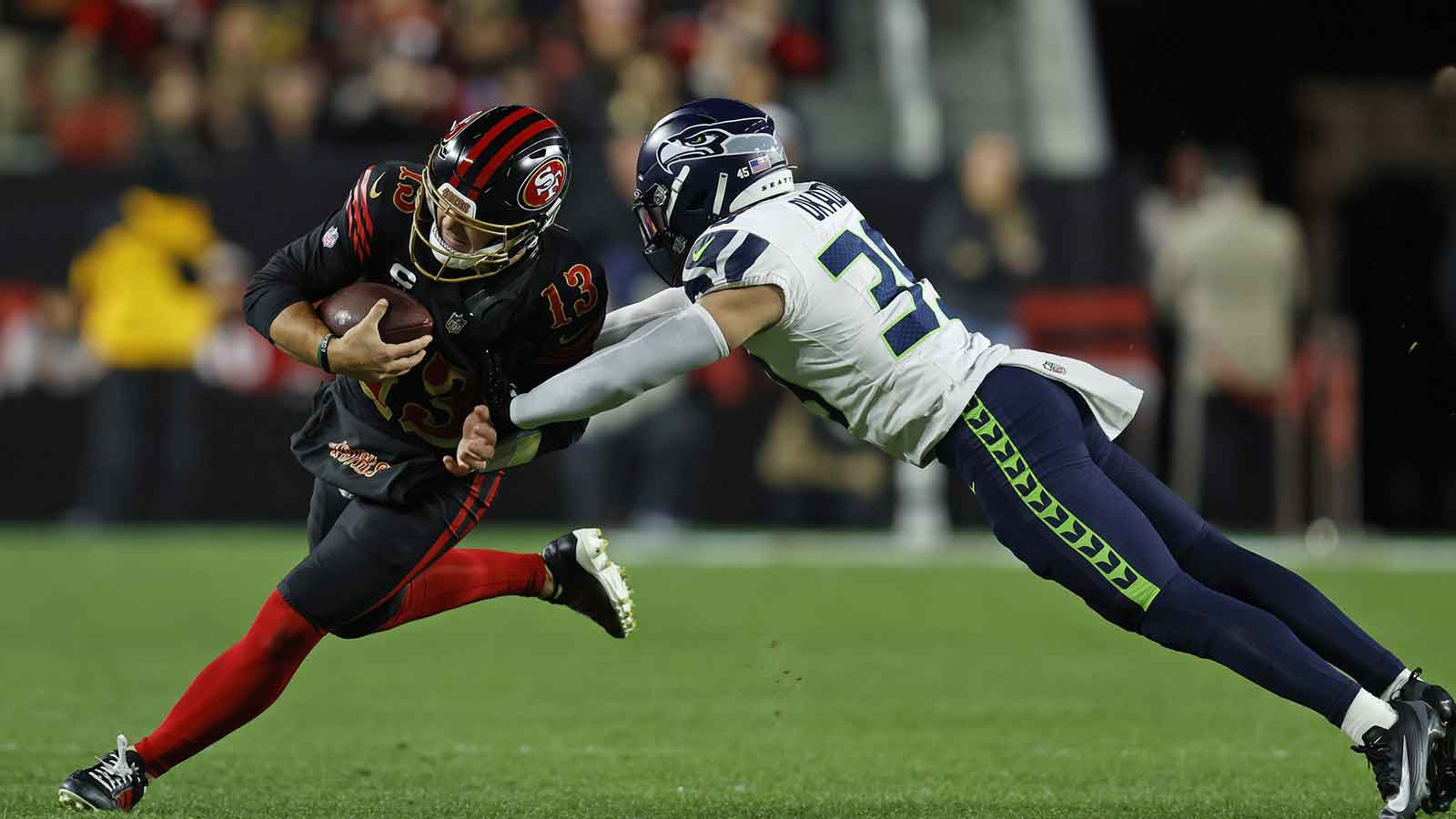 San Francisco 49ers quarterback Brock Purdy (13) rushes the ball past Seattle Seahawks safety Ty Okada (39) during the first half at Levi's Stadium. Mandatory Credit: Sergio Estrada-Imagn Images