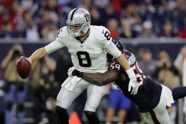 Raiders quarterback Connor Cook is sacked by Texans outside linebacker Whitney Mercilus during the second half of an AFC wild-card game Jan. 7, 2017, in Houston. (AP Photo/Eric Gay)