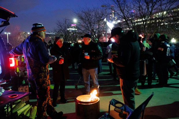 Fans stand near a fire while tailgating before the Chicago Bears play the Green Bay Packers in a NFC wild-card game at Soldier Field Jan. 10, 2026, in Chicago. (Armando L. Sanchez/Chicago Tribune)