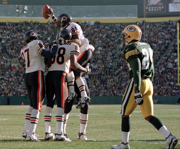 Green Bay Packers cornerback Antuan Edwards (24) walks away as Chicago Bears receiver Bobby Engram (81) is congratulated by teammates after catching a touchdown pass in the third quarter on Nov. 7, 1999, in Green Bay, Wisconsin. The Bears won 14-13. (Mike Roemer/AP)
