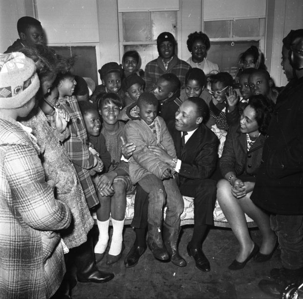 The Rev. Martin Luther King Jr. and his wife Coretta pose with neighborhood children in their new apartment at 1550 S. Hamlin Ave. in Chicago on Jan. 26, 1966. King and his family moved into the poor neighborhood to shed light on the living conditions of Black people in Chicago in 1966. (Tom Kinahan/Chicago Tribune) 
