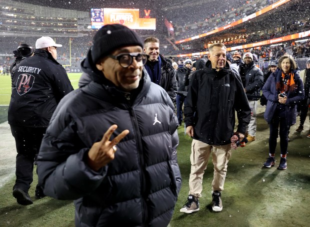 Rev. Michael Pfleger watches as Spike Lee poses for a photograph while hanging out on the field before the Chicago Bears and the Green Bay Packers face off in an NFC wild-card game at Soldier Field in Chicago on Jan. 10, 2026. (Chris Sweda/Chicago Tribune)