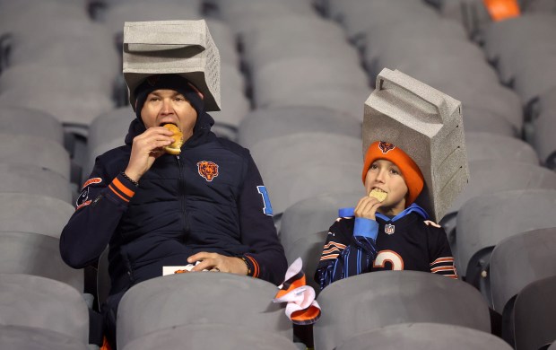 Chicago Bears fans wearing cheese grater hats relax in the stands before a NFC wild-card game between the Chicago Bears and the Green Bay Packers at Soldier Field in Chicago on Jan. 10, 2026. (Chris Sweda/Chicago Tribune)