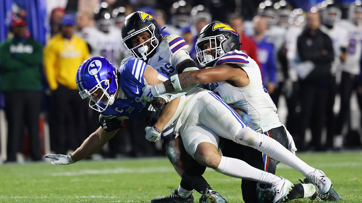 Brigham Young Cougars wide receiver Chase Roberts (2) is tackled short of a first by Kansas Jayhawks safety Marvin Grant (center) and linebacker Cornell Wheeler (44) to turn the ball over on downs during the fourth quarter at LaVell Edwards Stadium.
