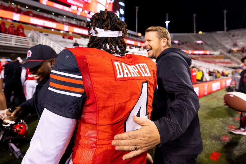 Utah offensive coordinator Jason Beck, right, walks off the field with quarterback Devon Dampier at Rice-Eccles Stadium after the Utes' victory over Arizona State Oct. 11, 2025.
