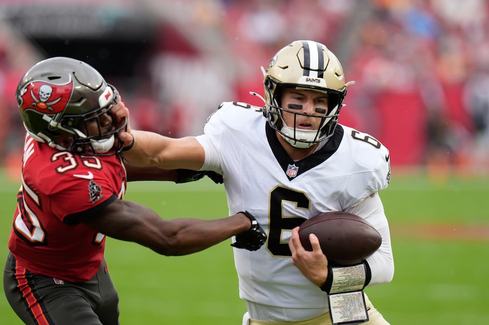Saints rookie quarterback Tyler Shough (6) throws a stiffarm into the facemask of Tampa Bay...