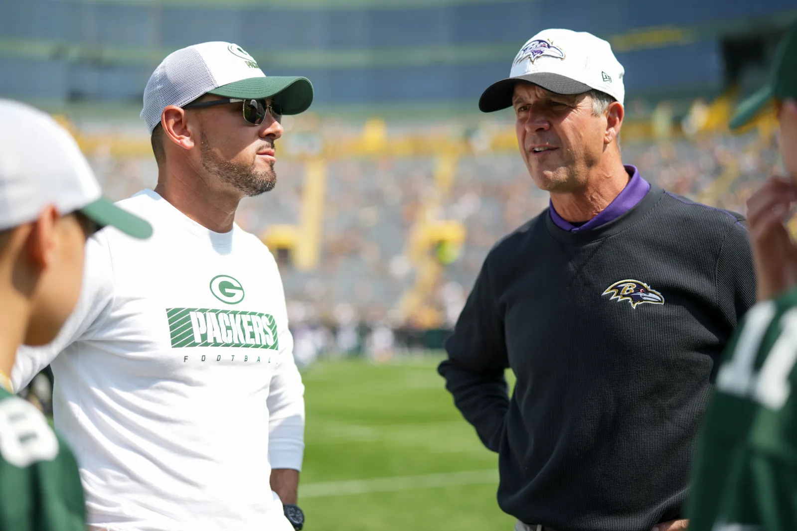 Head coach Matt LaFleur of the Green Bay Packers speaks with head coach John Harbaugh of the Baltimore Ravens