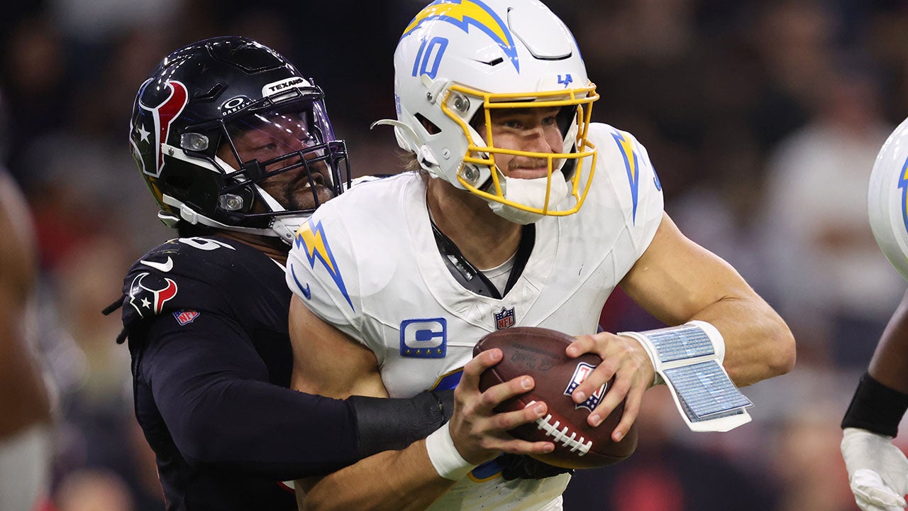 Denico Autry #96 of the Houston Texans sacks Justin Herbert #10 of the Los Angeles Chargers during the AFC Wild Card Playoffs at NRG Stadium on January 11, 2025 in Houston, Texas. (Tim Warner/Getty Images)