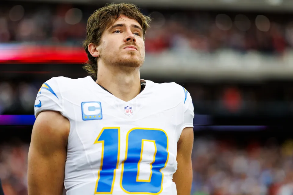 Justin Herbert of the Los Angeles Chargers stands on the sidelines during the national anthem prior to an AFC Wild Card game against the Houston Texans