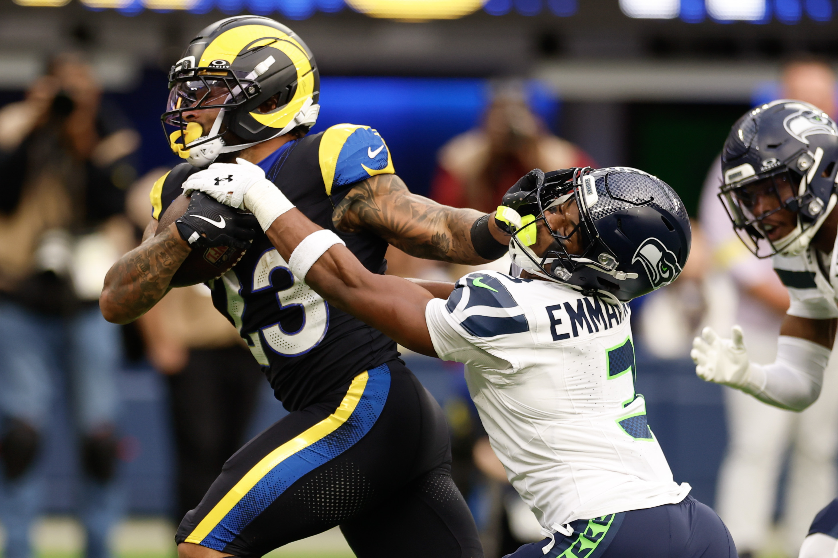 Rams running back Kyren Williams stiff-arms Seattle’s Nick Emmanwori during...