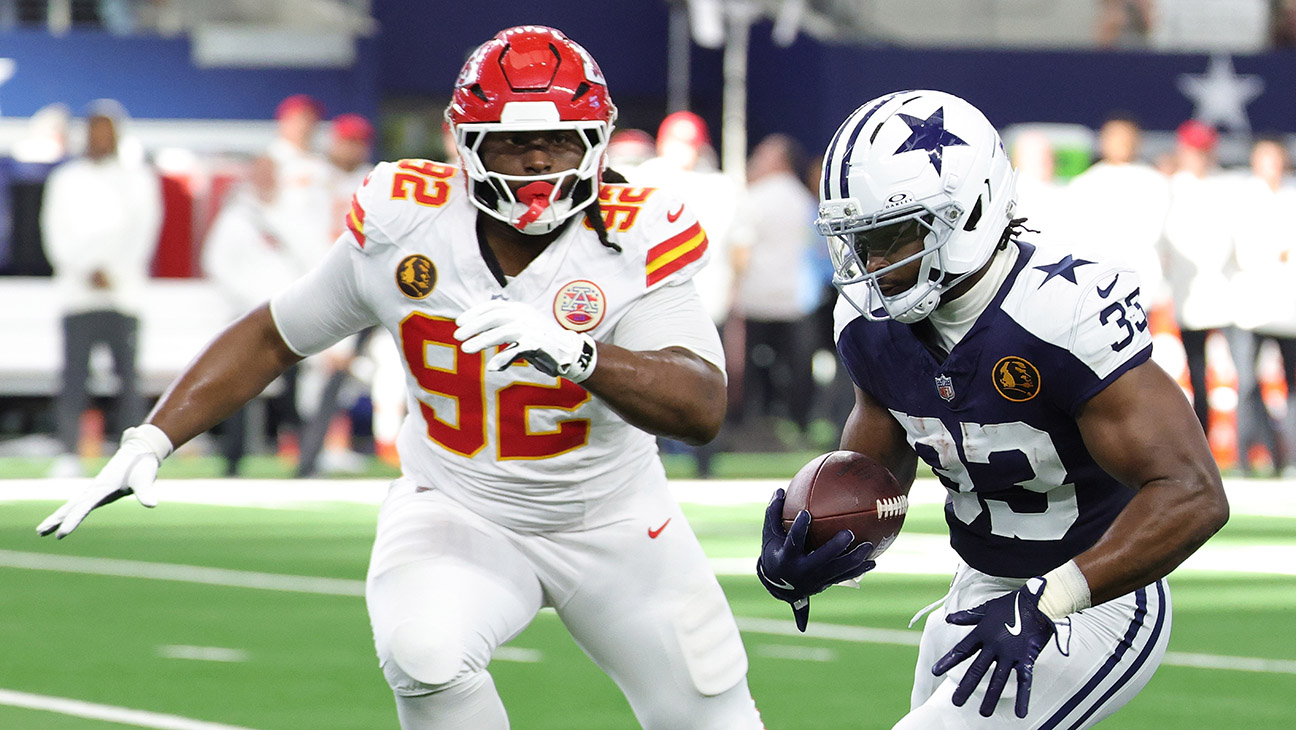 Javonte Williams #33 of the Dallas Cowboys is pursued by Derrick Nnadi #92 of the Kansas City Chiefs during a game at AT&T Stadium on November 27, 2025 in Arlington, Texas.