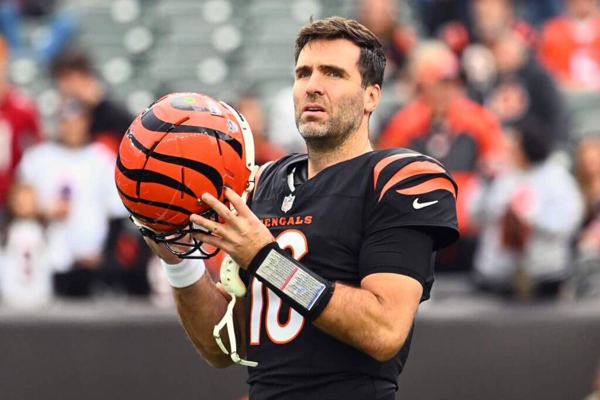 Joe Flacco, No. 16, of the Cincinnati Bengals holds his helmet before a game against the Arizona Cardinals.