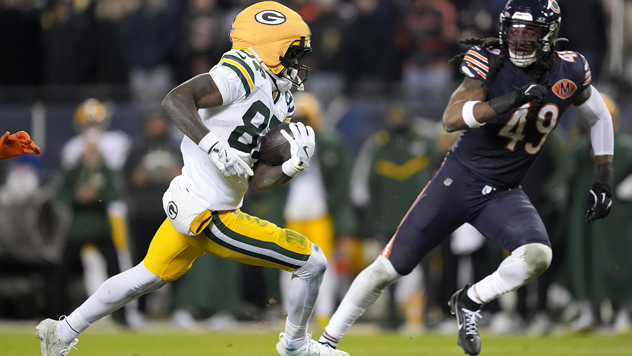 Romeo Doubs #87 of the Green Bay Packers runs the ball after a catch against Tremaine Edmunds #49 of the Chicago Bears during the fourth quarter in the NFC Wild Card Playoff game at Soldier Field on January 10, 2026 in Chicago, Illinois.
