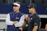 Dallas Cowboys head coach Brian Schottenheimer, left, speaks to Baltimore Ravens head coach...