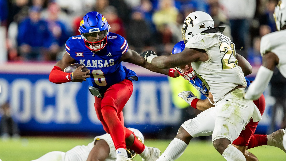 Nov 23, 2024; Kansas City, Missouri, USA; Kansas quarterback Jalon Daniels (6) scrambles the ball past a defender during the 4th quarter between the Kansas Jayhawks and the Colorado Buffaloes at GEHA Field at Arrowhead Stadium. Mandatory Credit: Nick Tre. Smith-Imagn Images