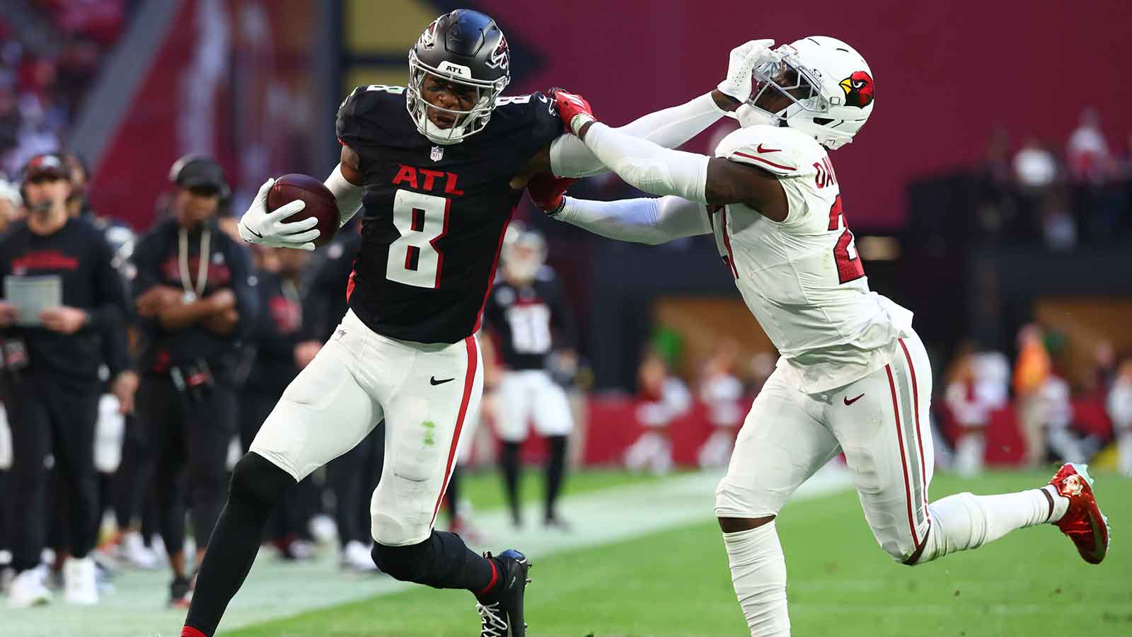 Atlanta Falcons tight end Kyle Pitts Sr. (8) runs after the catch and applies a stiff arm on Arizona Cardinals cornerback Akeem Davis (27) during the second half at State Farm Stadium.
