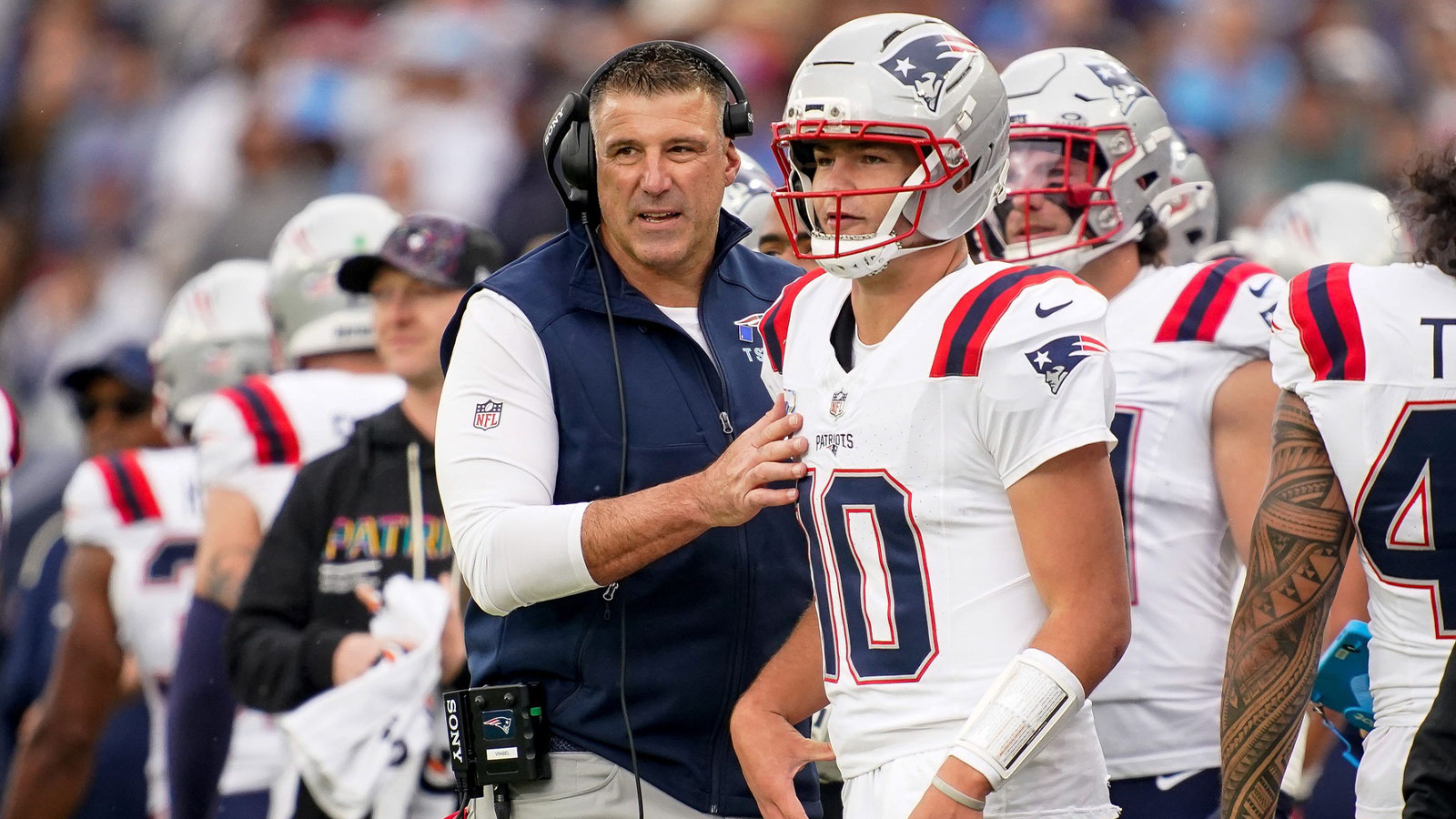 New England Patriots coach Mike Vrabel talks to quarterback Drake Maye (10) during the second quarter at Nissan Stadium in Nashville, Tenn., Sunday, Oct. 19, 2025.