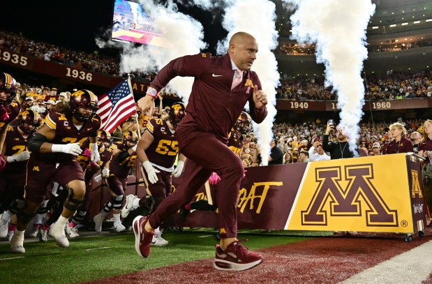 P.J. Fleck and his team run onto the field.