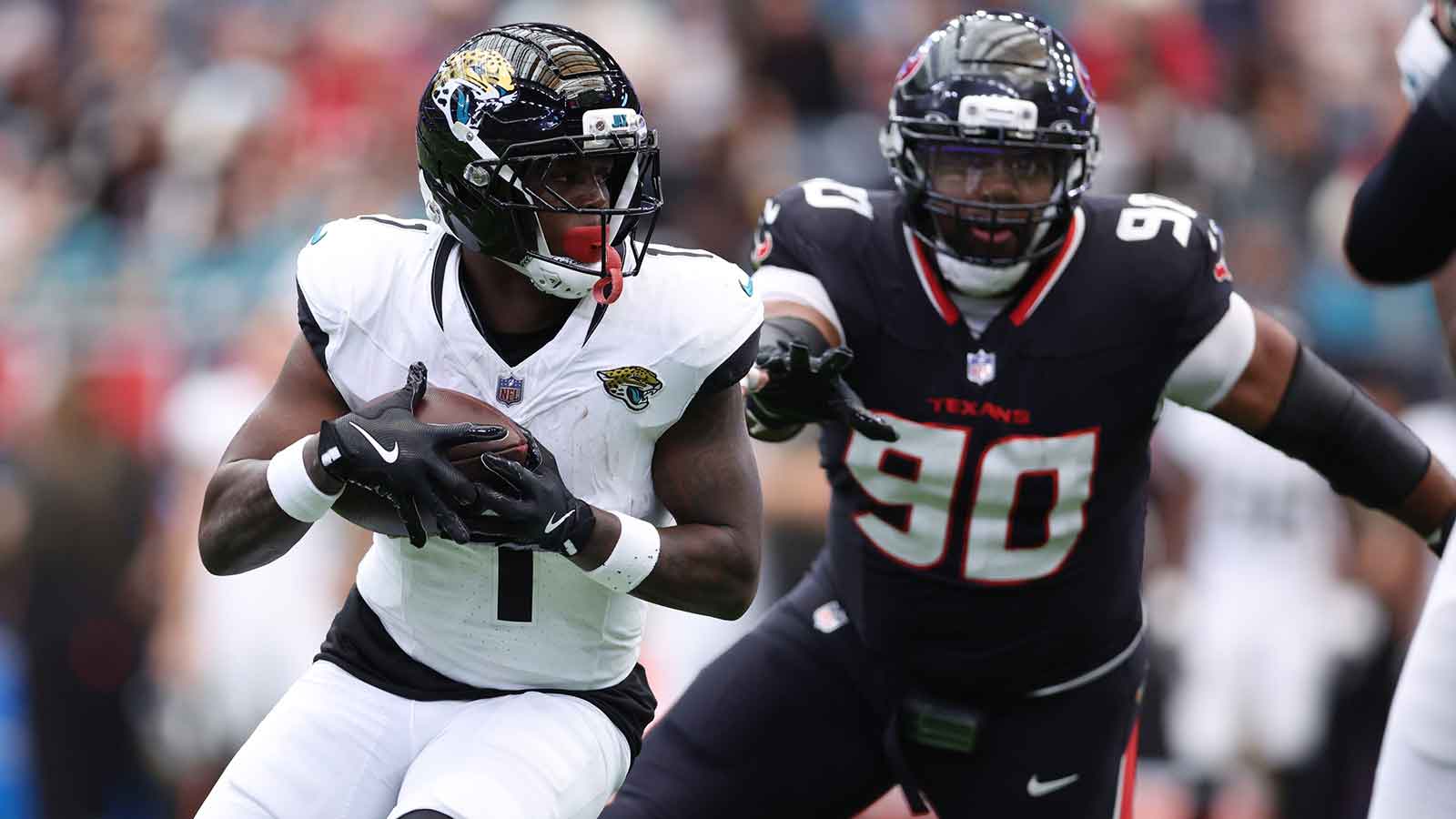Jacksonville Jaguars running back Travis Etienne Jr. (1) carries the ball as Houston Texans defensive tackle Sheldon Rankins (90) defends during the first half at NRG Stadium.