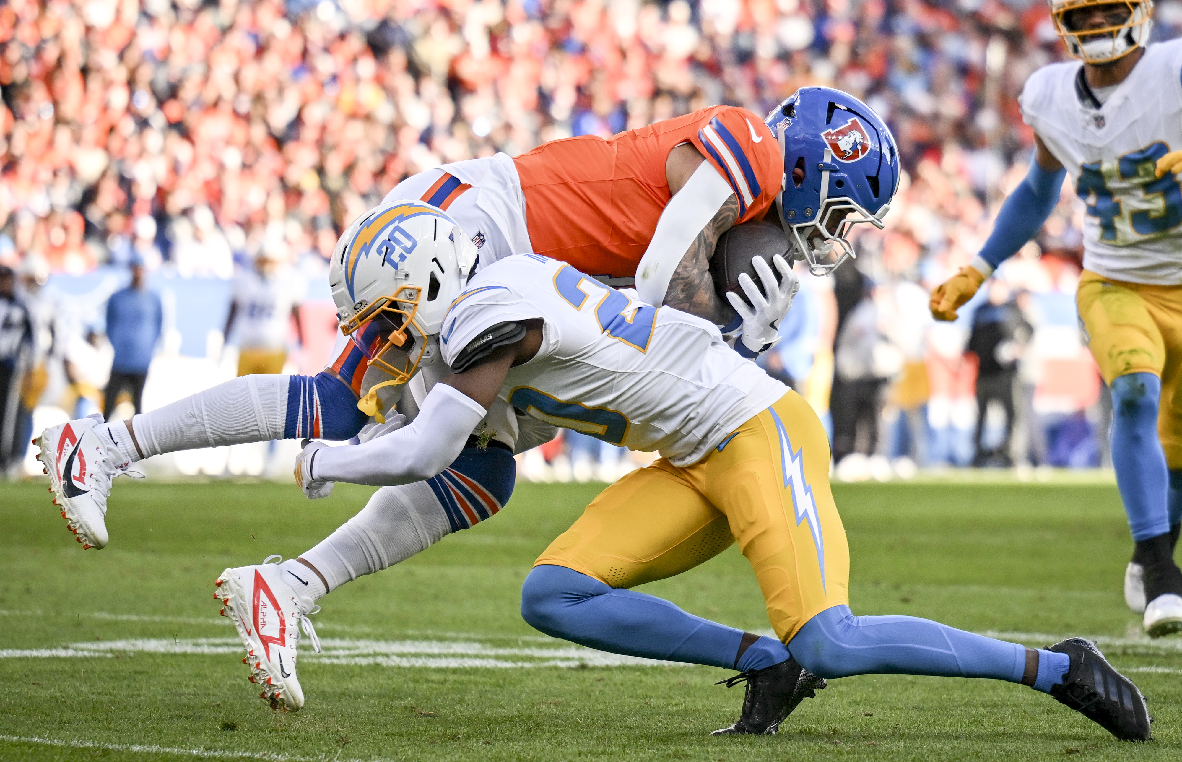 Cam Hart (20) of the Los Angeles Chargers tackles Evan...