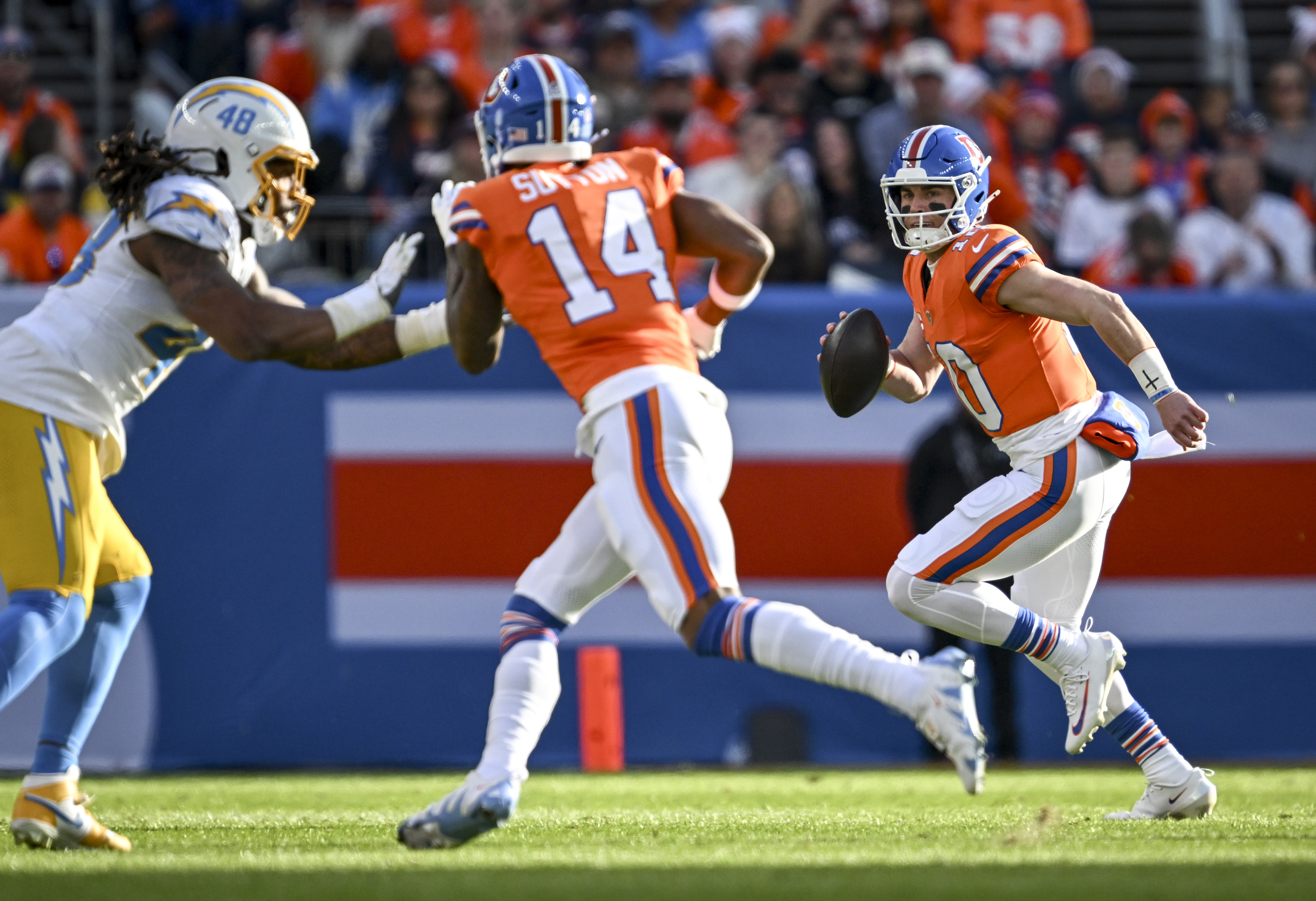 Bo Nix (10) of the Denver Broncos scrambles as Bud...