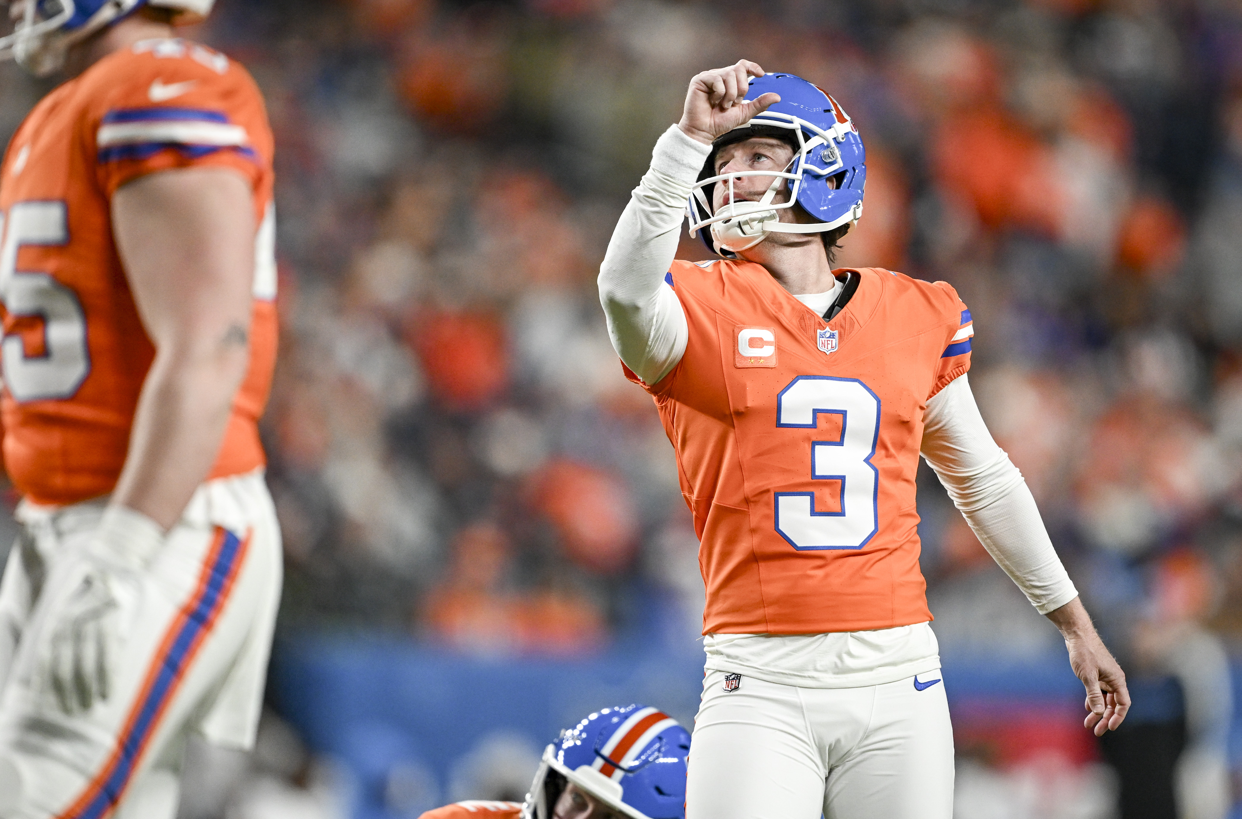 Wil Lutz (3) of the Denver Broncos knocks down a...