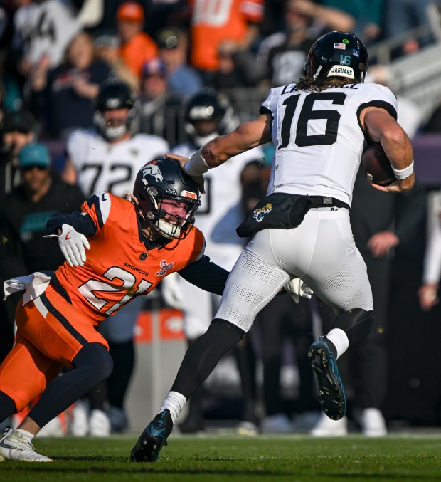 Riley Moss (21) of the Denver Broncos tackles Trevor Lawrence (16) of the Jacksonville Jaguars during the first quarter at Empower Field at Mile High in Denver, Colorado on Sunday, Dec. 21, 2025. (Photo by AAron Ontiveroz/The Denver Post)