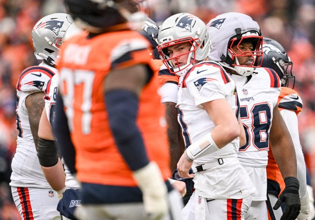 Drake Maye (10) of the New England Patriots reacts to being sacked by Malcolm Roach (97) and Eyioma Uwazurike (96) of the Denver Broncos during the second quarter at Empower Field at Mile High in Denver on Sunday, Jan. 25, 2026. (Photo by AAron Ontiveroz/The Denver Post)