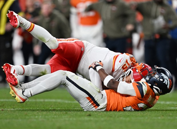 Ja'Quan McMillian (29) of the Denver Broncos, bottom, sacks Patrick Mahomes (15) of the Kansas City Chiefs at Empower Field at Mile High on Nov. 16, 2025. (Photo by RJ Sangosti/The Denver Post)