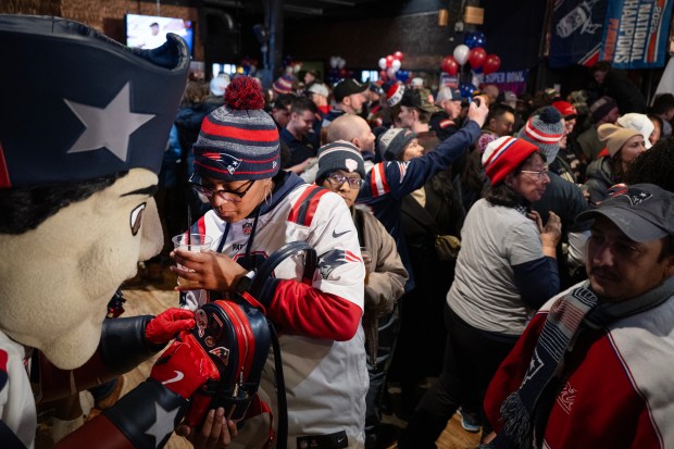 Patriot Pat signs New England Patriots fan Sumaya Faggan's bag on Saturday at Jackson's LODO in Denver. (Photo by Timothy Hurst/The Denver Post)