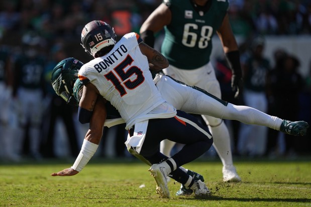 Denver Broncos linebacker Nik Bonitto (15) tackles Philadelphia Eagles quarterback Jalen Hurts (1) during the second half of an NFL football game Sunday, Oct. 5, 2025, in Philadelphia. (AP Photo/Matt Rourke)