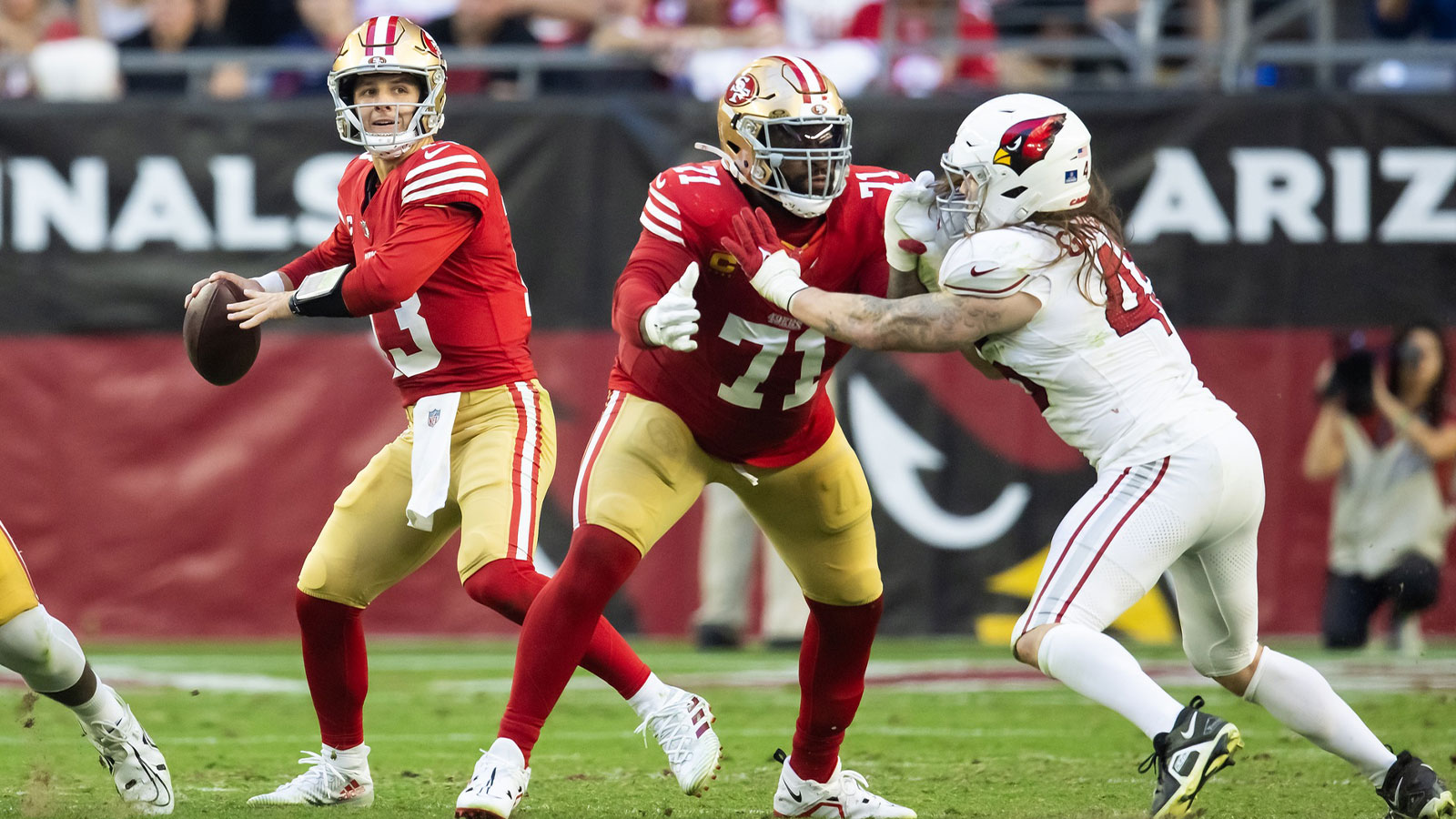 San Francisco 49ers offensive lineman Trent Williams (71) blocks for quarterback Brock Purdy (13) against Arizona Cardinals linebacker Dennis Gardeck (45) at State Farm Stadium.
