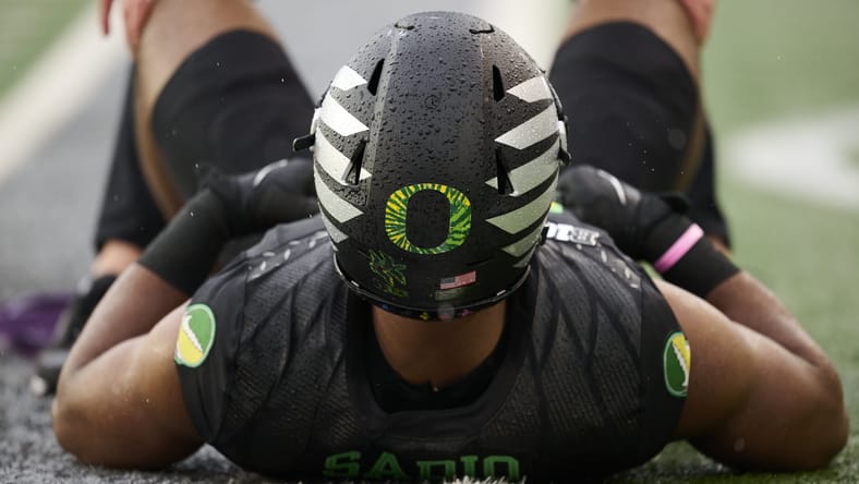 Kenyon Sadiq warming up before an Oregon game against Wisconsin at Autzen Stadium. Vikings draft trade with Eagles.