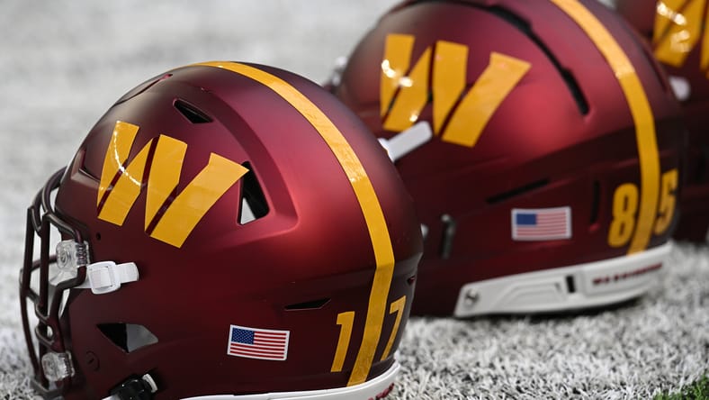 Washington Commanders helmet on the sideline before a 2025 game at U.S. Bank Stadium. Minnesota Vikings T.J. Hockenson cut rumors.