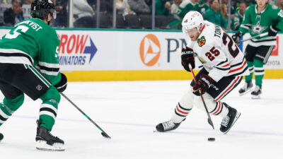 Dec 27, 2025; Dallas, Texas, USA; Chicago Blackhawks center Dominic Toninato (25) skates with the puck against Dallas Stars defenseman Nils Lundkvist (5) during the first period at American Airlines Center. Mandatory Credit: Chris Jones-Imagn Images