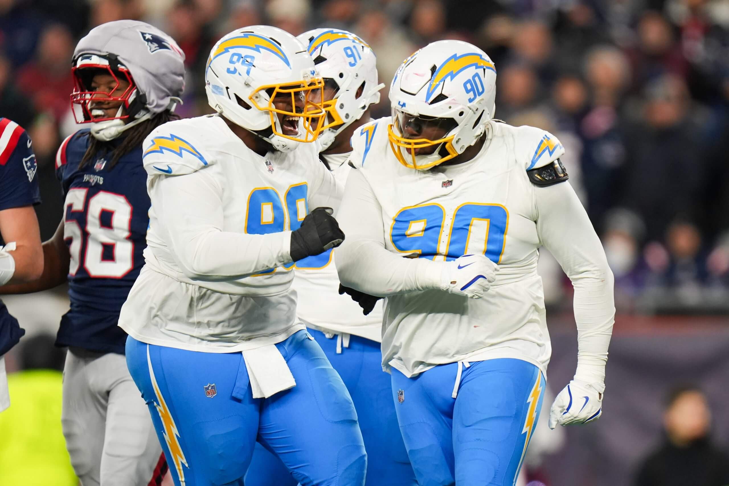 Los Angeles Chargers defensive tackle Teair Tart (90) celebrates a sack with Los Angeles Chargers defensive tackle Jamaree Caldwell (99) during the third quarter against the New England Patriots in an AFC Wild Card Round game at Gillette Stadium.