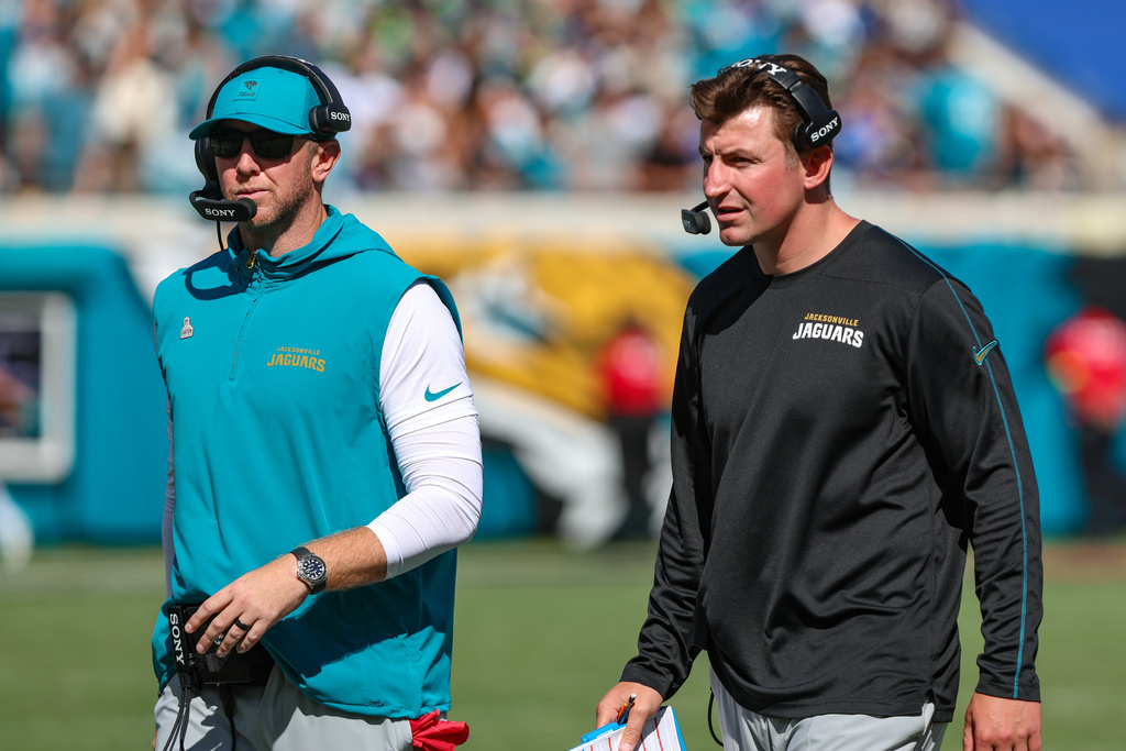 Jacksonville Jaguars head coach Liam Coen, and offensive coordinator Grant Udinski, right, walk to the sideline during an NFL football game against the Seattle Seahawks, Sunday, Oct. 12, 2025, in Jacksonville, Fla. The Seahawks defeated the Jaguars 20-12. 