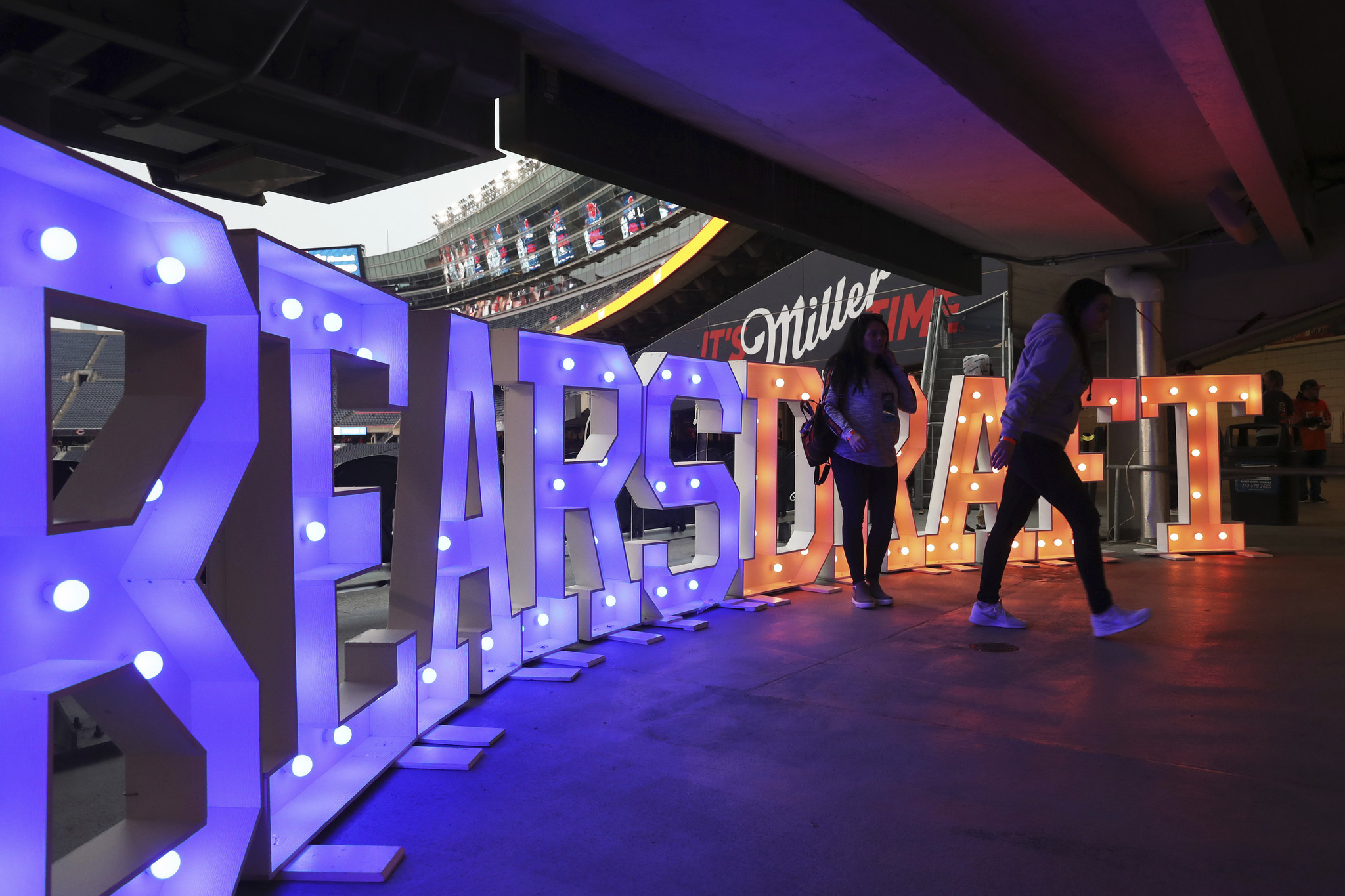 Fans walk past a sign during the Bears NFL draft...