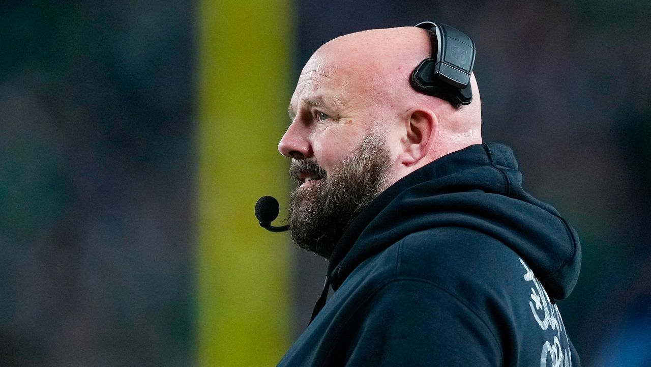 Brian Daboll stands on football sideline with headset on