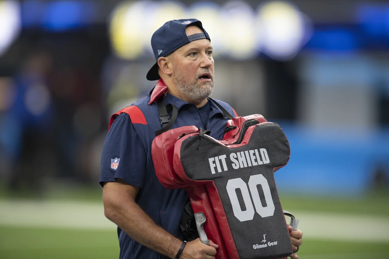 New England Patriots offensive line coach Carmen Bricillo works with his players before an NFL football game against the Los Angeles Chargers Sunday, Oct. 31, 2021, in Inglewood, Calif. (AP Photo/Kyusung Gong)